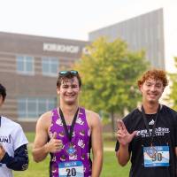 Three participants showing their top 10 medals.